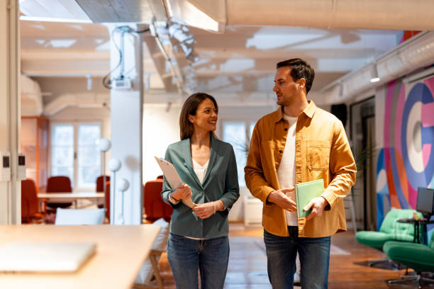istock Two businesspeople walking and talking in the office 2196238244