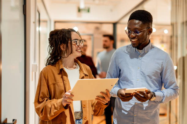 istock Young colleagues walking and talking in the office corridor 2196238434