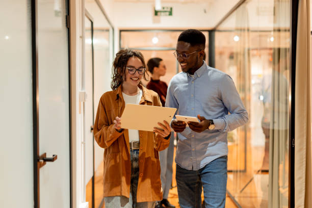 istock Young businesspeople walking and talking about work in office corridor 2196238454