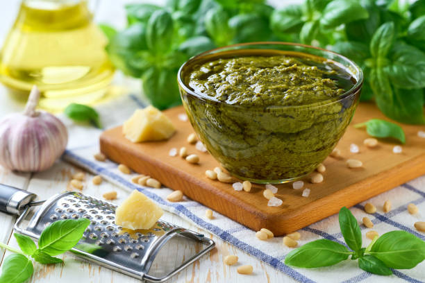 istock Traditional italian sauce pesto in a bowl with basil leaves on a light kitchen table table. 2196240658