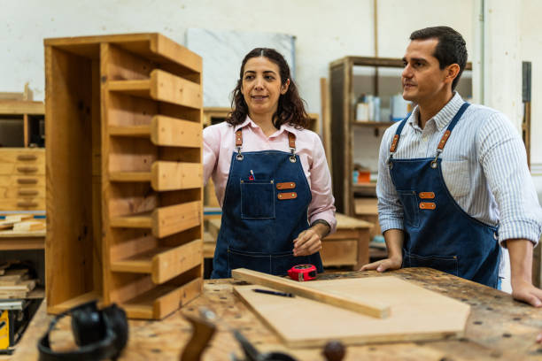 istock Mid adult carpenters talking and working at carpentry 2196240699