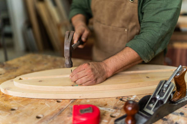 istock Close-up of a carpenter nailing a nail at carpentry 2196240923