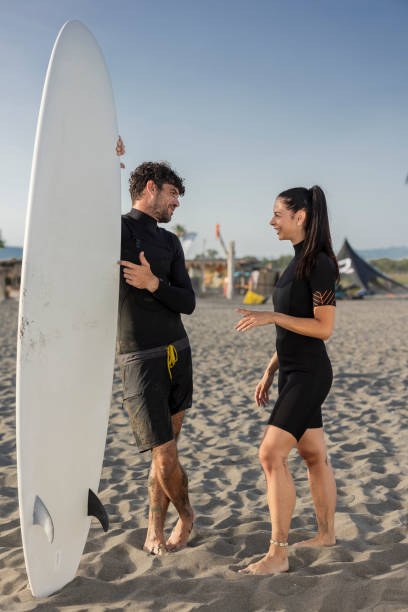 istock Surfers chatting on the beach after a surfing session 2196241211