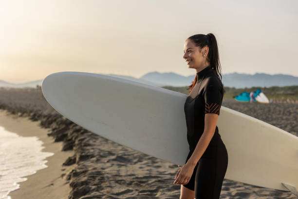 istock Young woman enjoying surfing on sandy beach 2196241267
