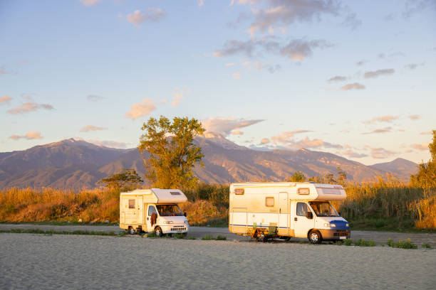 Vintage campers on the Greek coast during golden hour with mount Olympus in the background