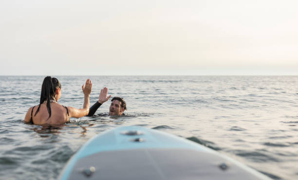 istock Friends celebrating a successful surfing session at sea 2196241379