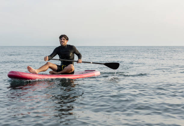 istock Man enjoying paddleboarding on calm ocean water 2196241396
