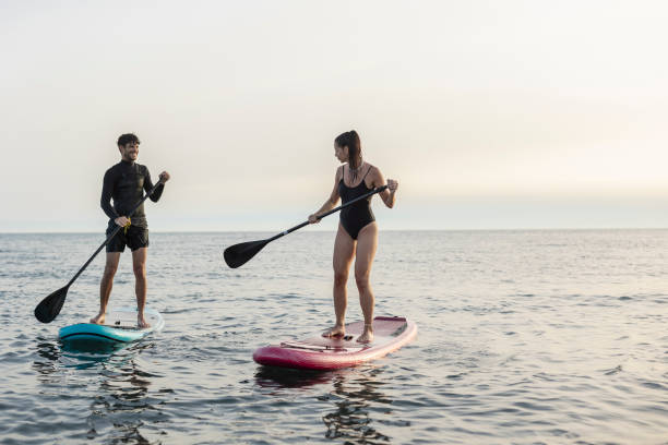 istock Young couple enjoying stand up paddleboarding adventure 2196241413