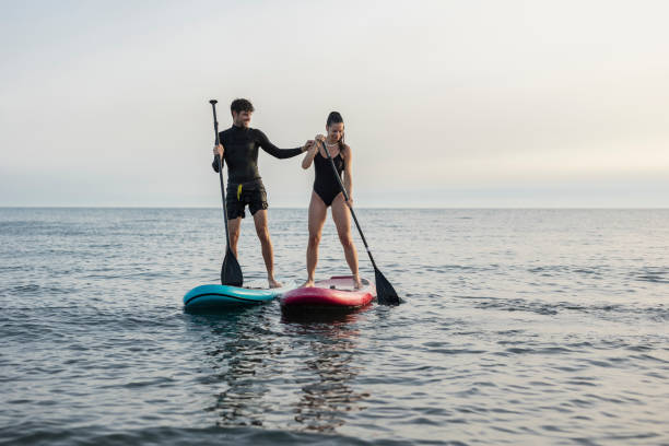 istock Couple enjoying stand up paddleboarding on calm sea 2196241425