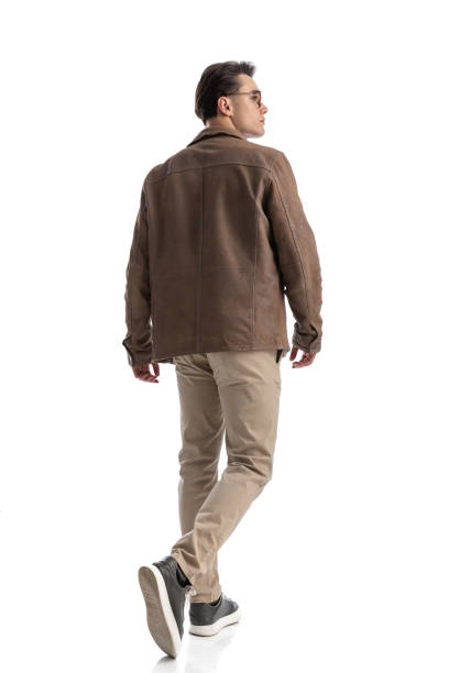 istock rear view of young man walking and looking to side 2196241475