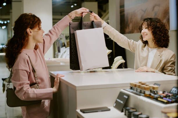 istock Seller Passing Paper Bags to Client 2196241629