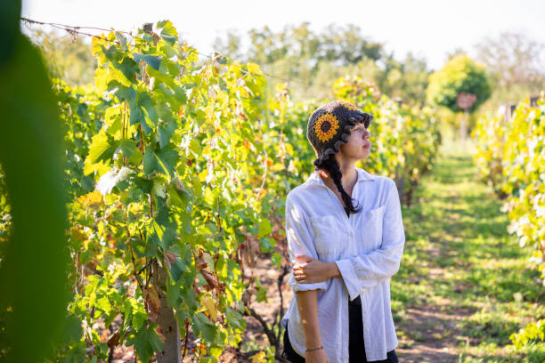 istock Woman with a beanie hat walking in her vineyard 2196242481