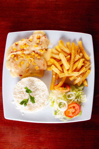 istock chicken stroganoff with corn, fries, rice and salad 2196245083