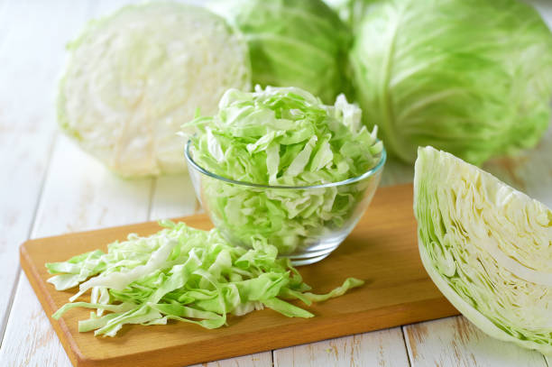 istock shredded cabbage in a clear glass bowl on a white wooden table. 2196247248