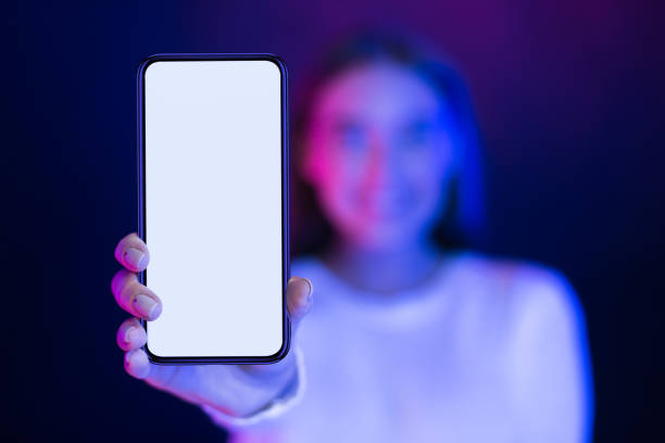 istock Person Holding a Smartphone With Blank Screen Against Colorful Lighting Backdrop 2196247696