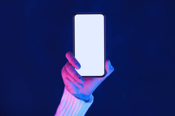 istock Hand Holding Blank Smartphone Under Vibrant Blue and Purple Lighting 2196247721