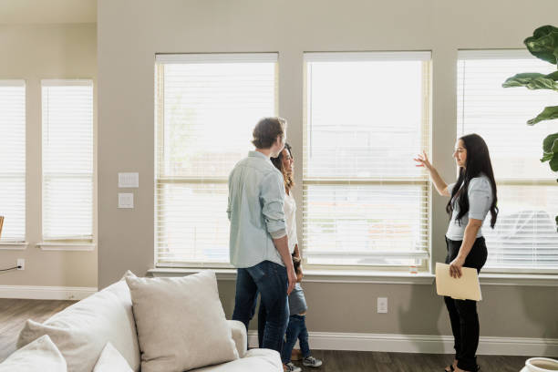 istock Happy Couple Viewing New Home with Real Estate Agent 2196248037