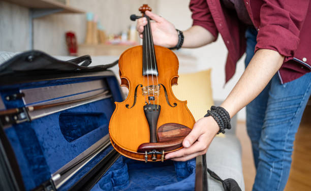 istock Hands of a man placing his violin in a case 2196248735
