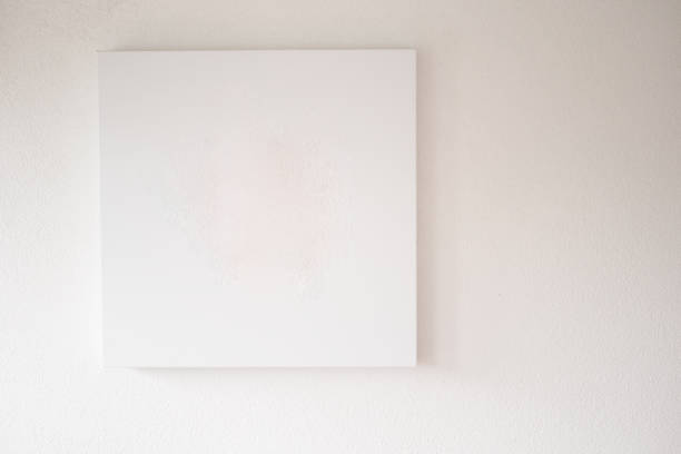 istock A Minimalist Empty Canvas Displayed on a White Wall, Perfect for Artistic Backgrounds 2196252300
