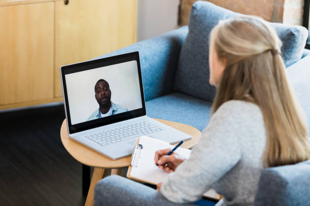 istock Online Therapy Session: Woman on Laptop, Taking Notes 2196253357