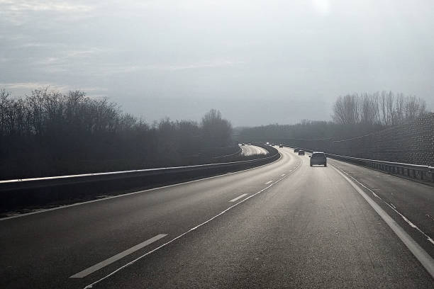 A sunlit motorway with distant cars, stretching towards the horizon, capturing the essence of travel, speed, and the open road.