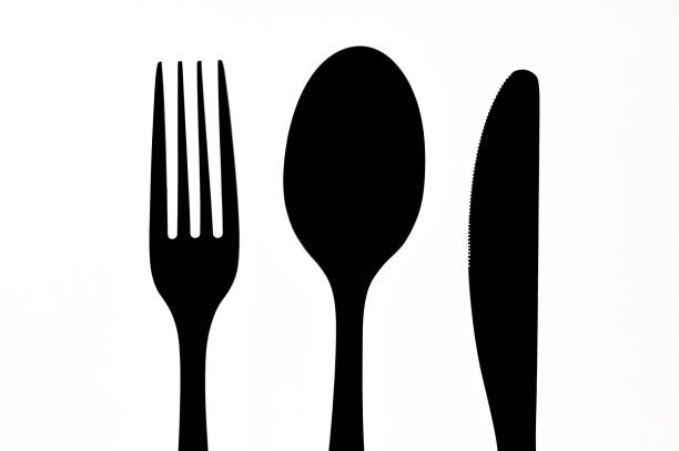 Black food plate with cutlery set layered isolated on white background flat lay view , Food concept photography