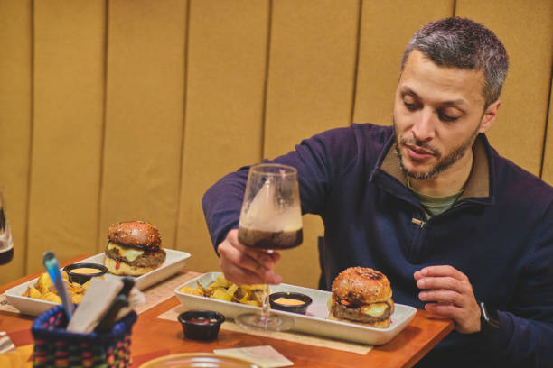 istock Young man ready to eat a burger in craft beer bar 2196260535