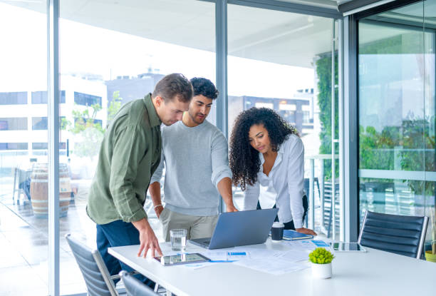 istock Team of three business people working on a laptop computer. 2196261667