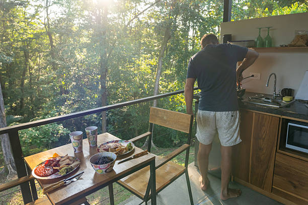 istock Person Cooking Breakfast in a Cozy Kitchen with Scenic Forest View 2196262698