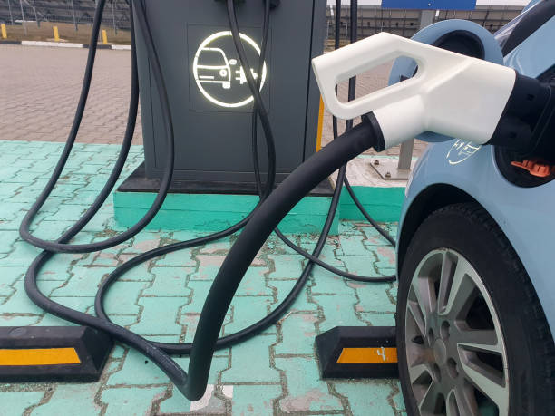 istock Power cable pump plug in charging power to electric vehicle EV car with modern technology UI control information display, car fueling station connected power cable alternative sustainable eco energy 2196264642