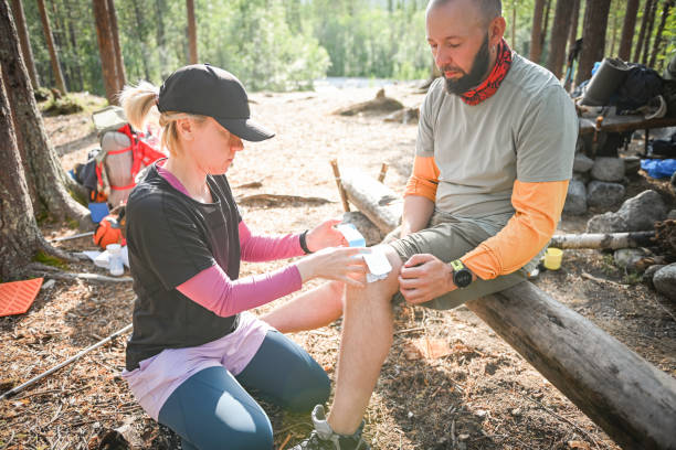 istock Two hikers take a break at a forest camp, attending to a minor injury while surrounded by nature. 2196268780