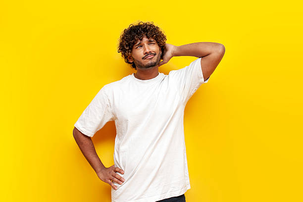 istock young indian puzzled guy thinks and remembers and scratches his head on yellow isolated background 2196269996