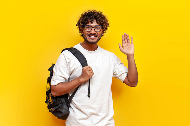 istock young indian guy student in glasses with backpack greets on yellow isolated background 2196270013