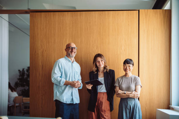 istock Professional Team Smiling in Modern Office Interior Against Wooden Panel Wall 2196270983