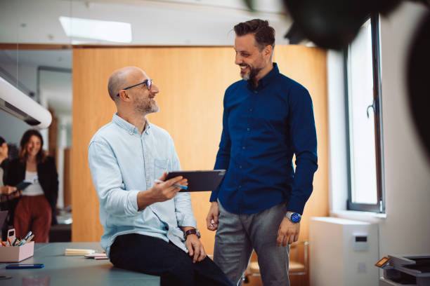 istock Two Businessmen Discussing Ideas in a Modern Office Environment 2196270985