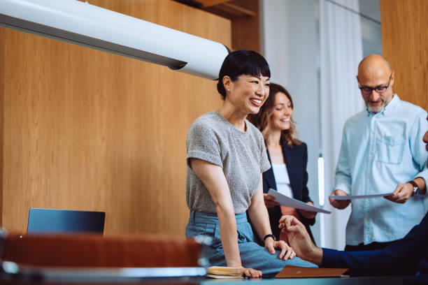 istock Group of Colleagues Collaborating and Smiling During an Office Meeting 2196271045