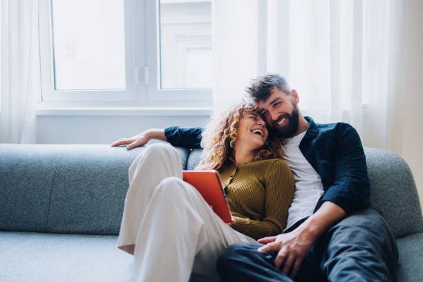 Happy Couple Relaxing Together on a Couch in a Bright Comfortable Home