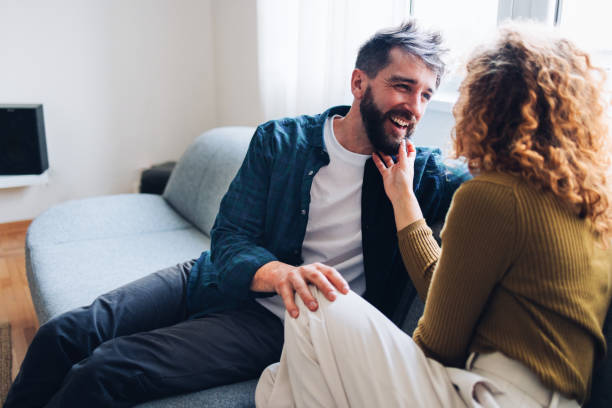 istock Happy Couple Laughing Together on a Cozy Couch Indoors 2196271186