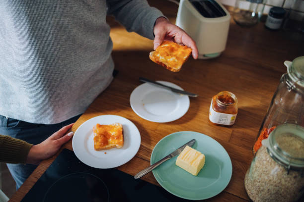 Preparing Toast with Butter and Jam in a Cozy Kitchen Setting