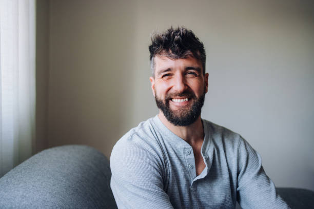 istock Smiling Man in Casual Attire Relaxing on a Comfy Sofa Indoors 2196271276