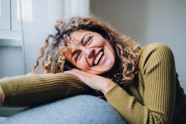 istock Smiling Young Woman Relaxing Indoors on a Comfortable Sofa 2196271284
