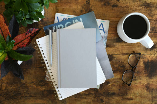 Blank hardcover book cover for mock up  on a pile of books and papers on a desk