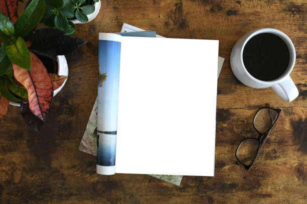 istock An open magazine laying on a table or desk with a white blank page for mock up. 2196271542