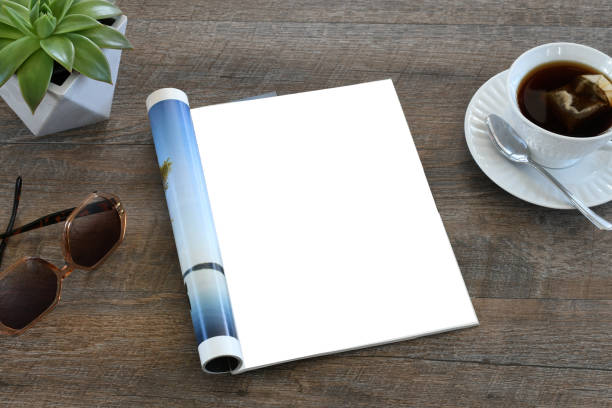 istock An open magazine laying on a table or desk with a white blank page for mock up. 2196272946