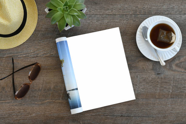 istock An open magazine laying on a table or desk with a white blank page for mock up. 2196272949