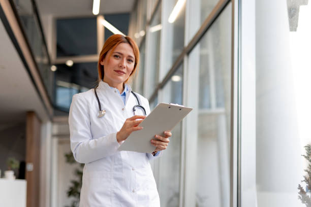istock Confident Female Doctor Smiling While Writing on a Clipboard in Hospital Setting 2196274237