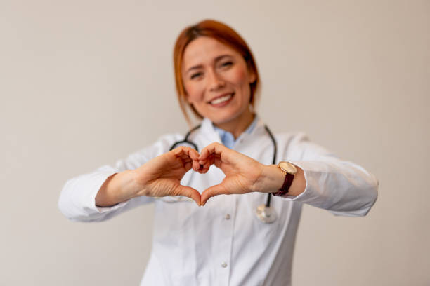 istock Smiling Doctor in Uniform Showing Heart Shape Gesture with Hands 2196274283