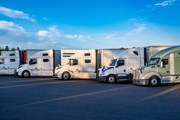 istock Professional big rig semi trucks with different semi trailers standing in row on truck stop parking lot waiting for the continuation of the route 2196276320