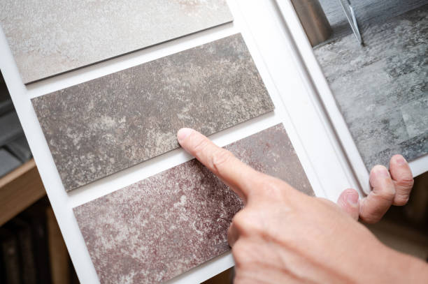 istock Flooring material design collection. Designer hand pointing at stone tile sample on display catalog. Customer choosing rough texture and pattern for floor finishing at home design store 2196284450