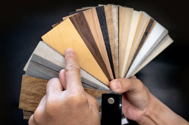 istock Designer hand pointing at sample of wood laminated material from natural collection. Customer choosing wooden veneer texture or set of MDF board swatch fan for interior finishing or furniture design 2196284682